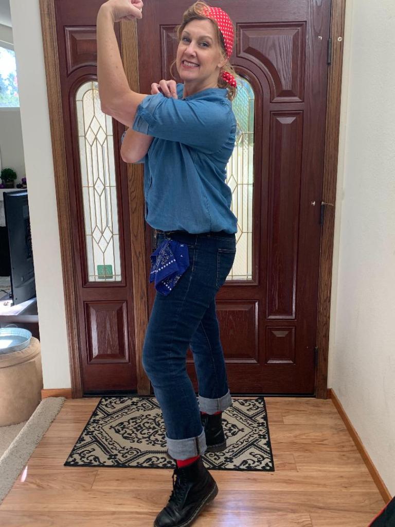 Writer is adult and wears a Rossie the Riveter costume — possing in the classic strong-arm/showing muscle pose. 
